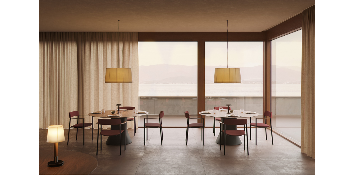 Perxa chairs upholstered in burgundy with wooden armrests around round tables in a restaurant overlooking the sea