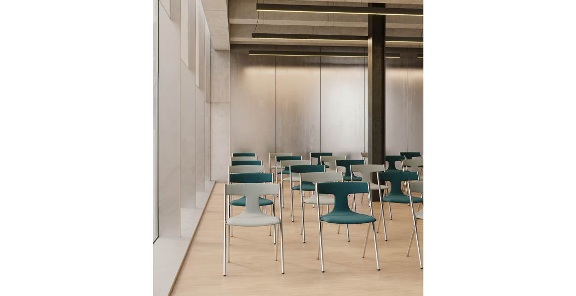 Quadra chairs fully upholstered in teal and light grey, with chrome legs, arranged in rows in a hall with a light wood floor